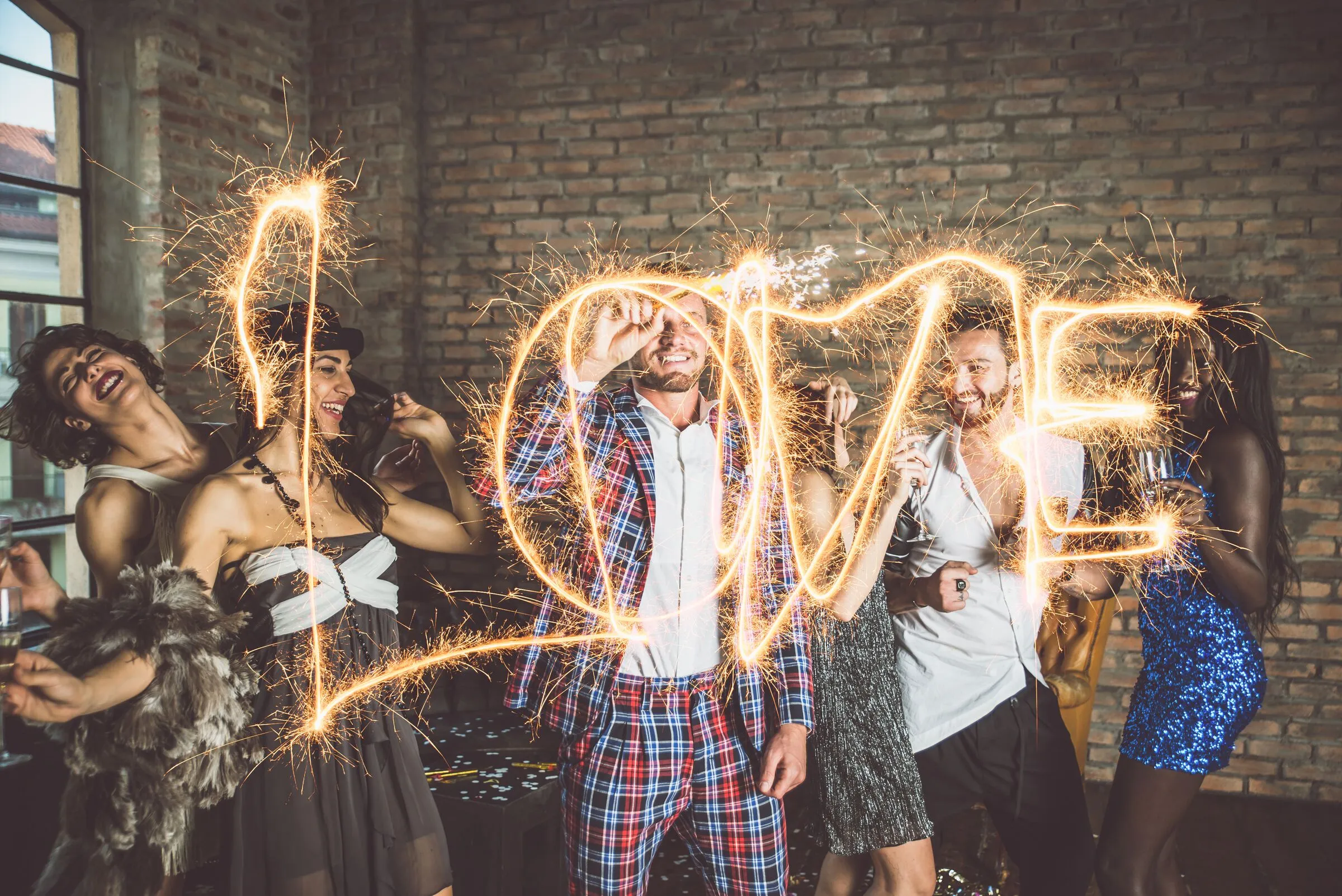 Goście z zimnymi ogniami tworzący napis LOVE